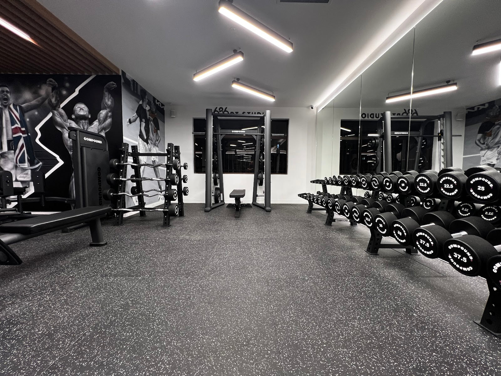 Open studio floor with mirror wall in a boutique gym by Compound Fitness