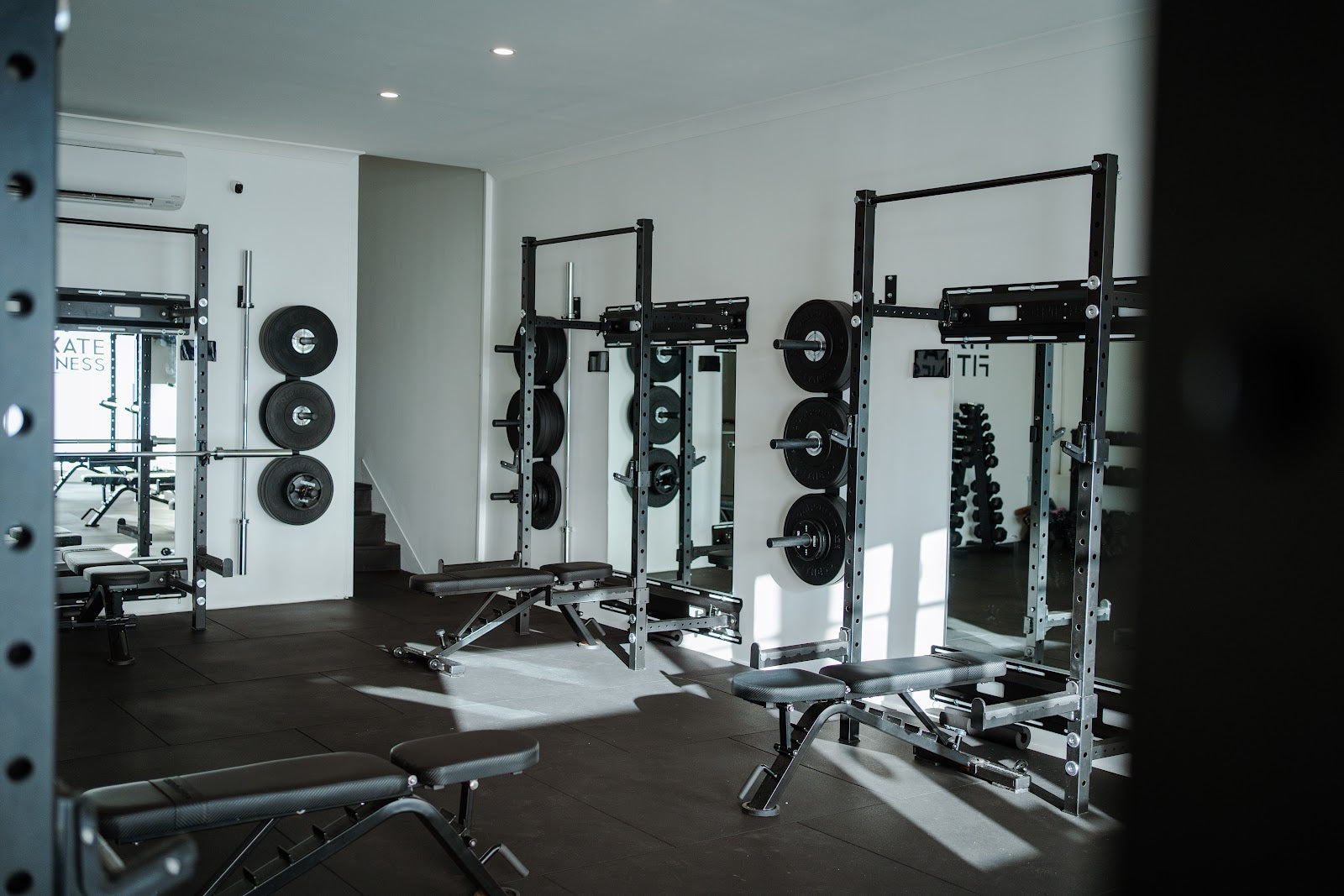 Rack and bench row with natural light in a boutique studio by Compound Fitness