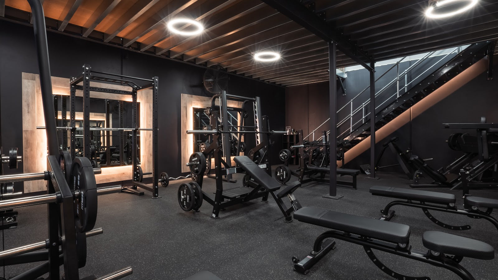 Boutique gym with squat racks, benches and staircase by Compound Fitness
