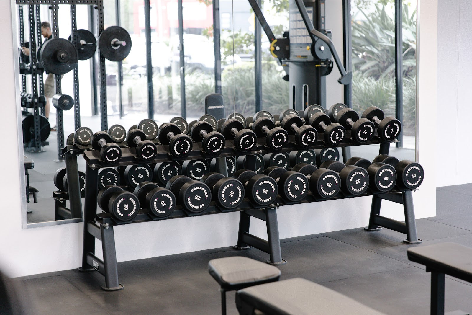 Dumbbell floor with mirror wall and greenery in a boutique studio by Compound Fitness