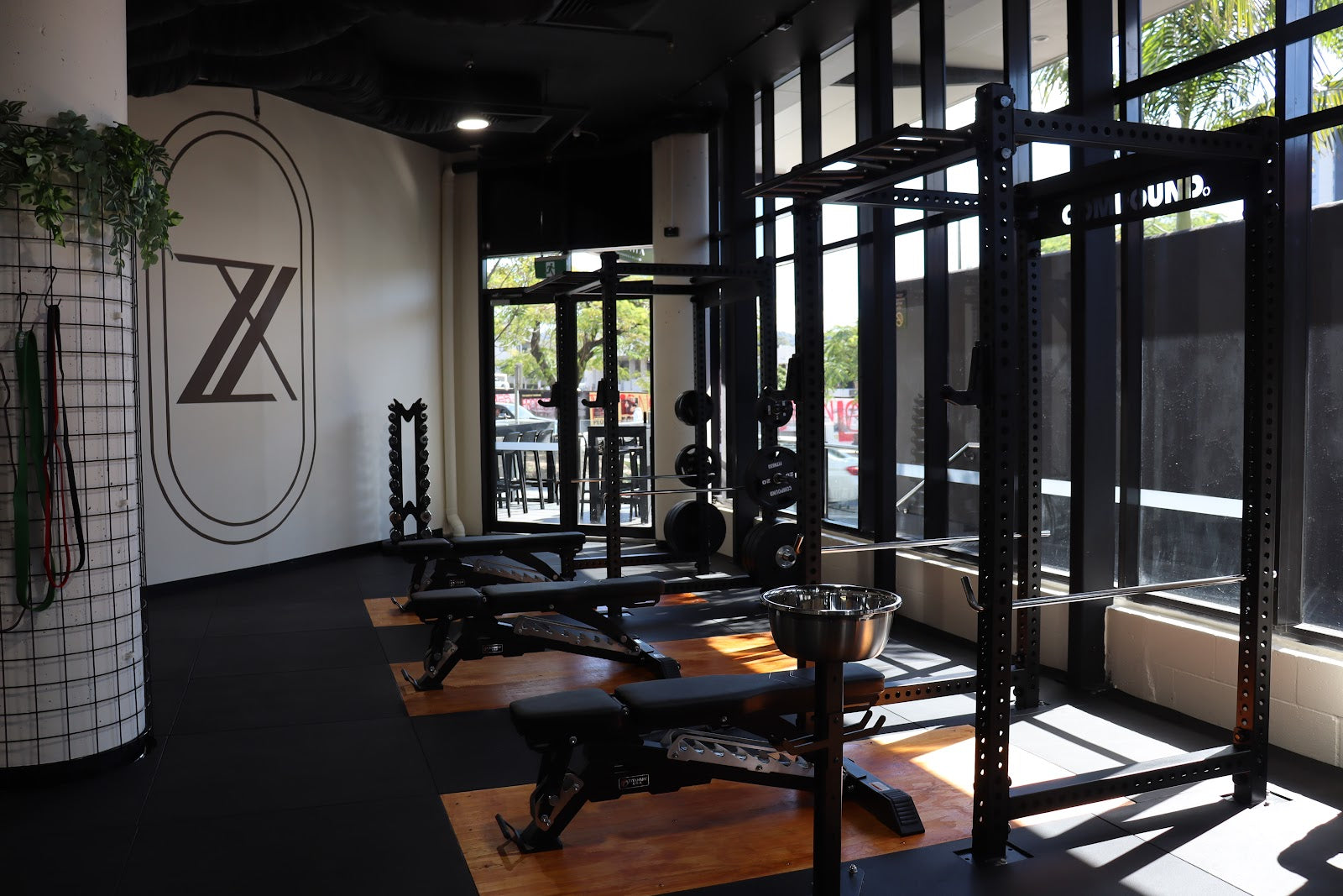 Branded corner with racks and benches in a boutique gym by Compound Fitness