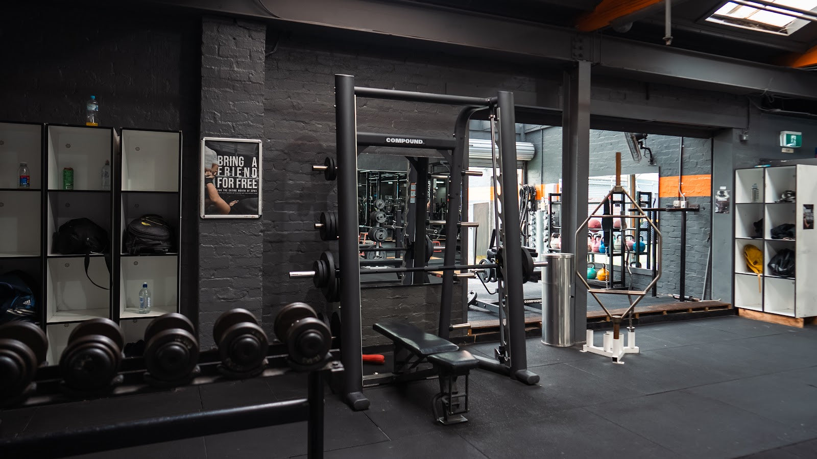24/7 gym floor with smith machine, dumbbell wall and lockers by Compound Fitness