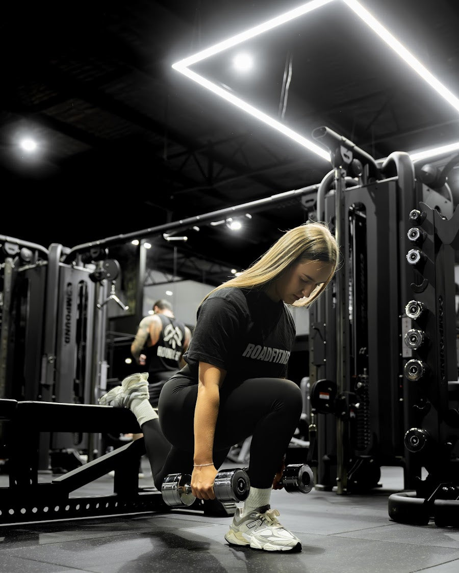 Member training on a lat pulldown under feature lighting in a 24/7 gym