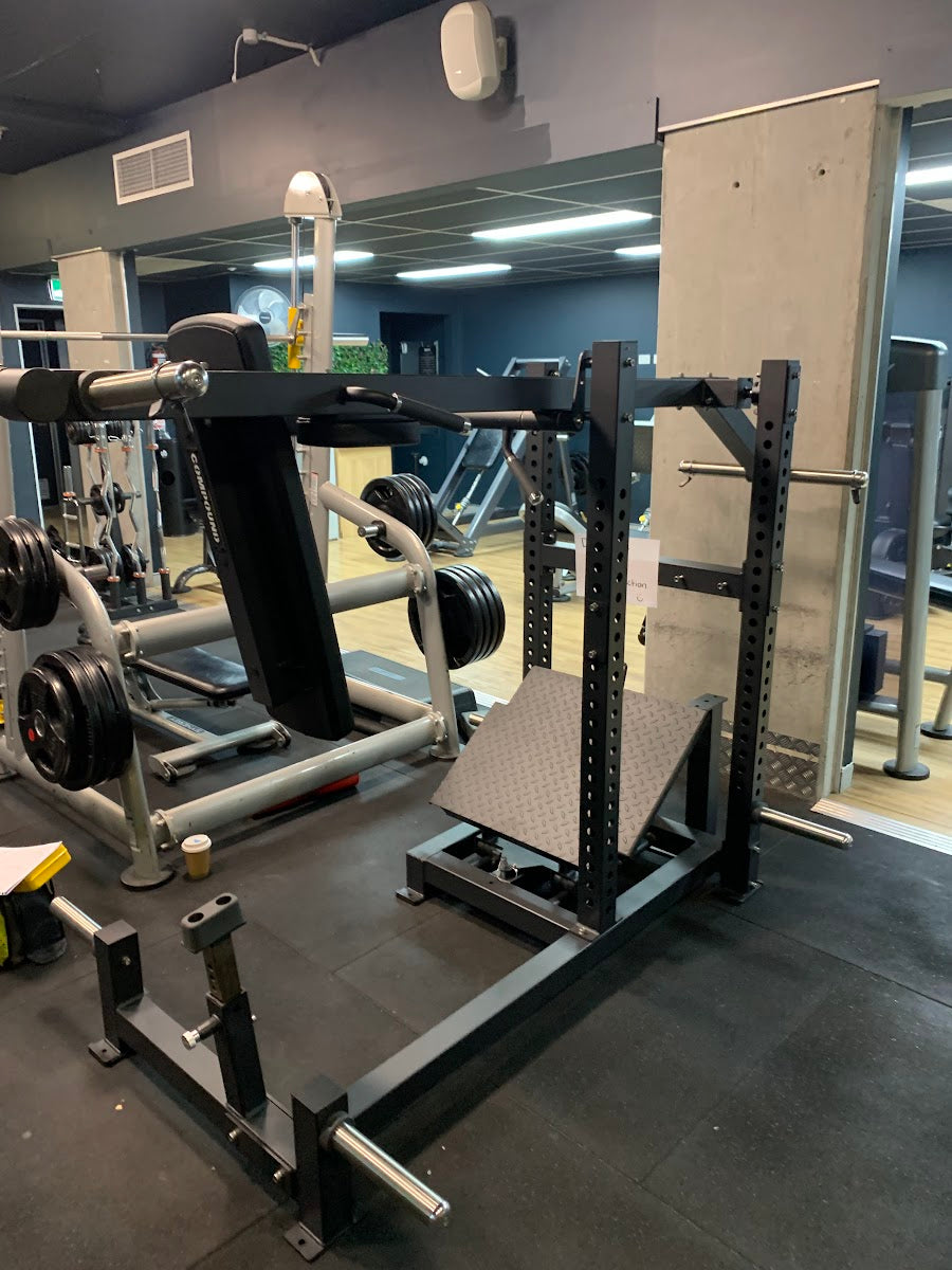 Commercial machines with cardio area behind in a 24/7 gym by Compound Fitness