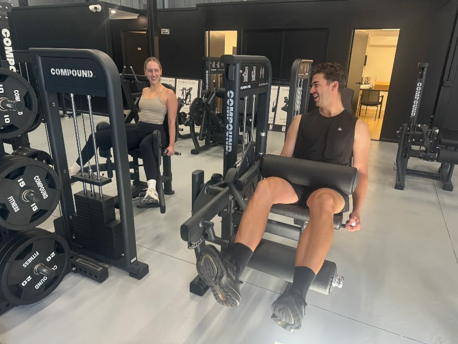 Members training on pin-loaded machines in a 24/7 gym fitout by Compound Fitness