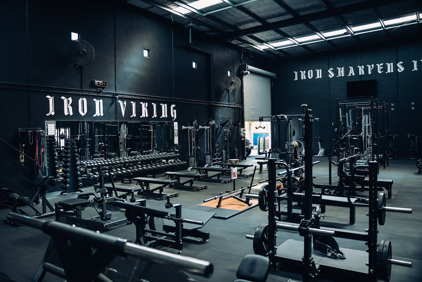 Warehouse strength gym fitout with racks, benches and dumbbell wall by Compound Fitness