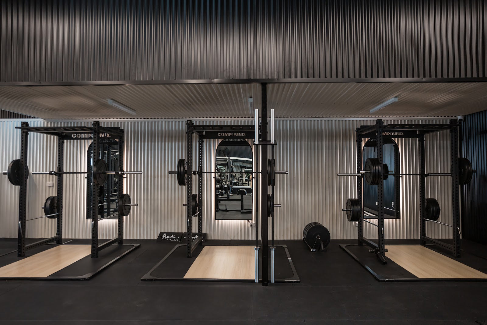 Power rack row on lifting platforms in a 24/7 gym fitout by Compound Fitness