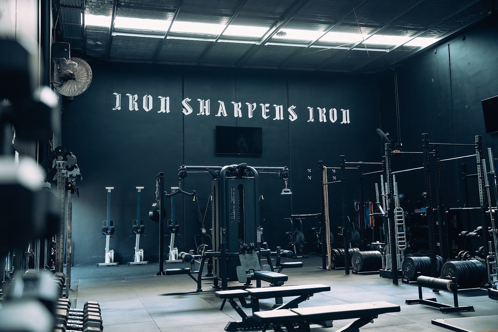 Free weights floor and cable stations in a warehouse 24/7 gym by Compound Fitness