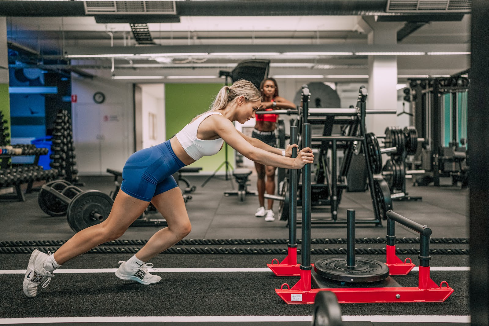 Sled turf lane with racks and benches in a 24/7 gym fitout by Compound Fitness